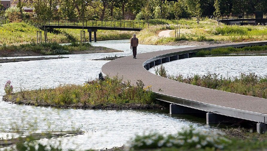 Over het vlonderpad wandelt een bezoeker.